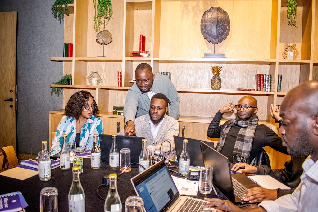 Pawa IT CTO Oscar Limoke debugging a Cloud Run container build with attendees at their table during Cloud Mastery 2026 in Nairobi.