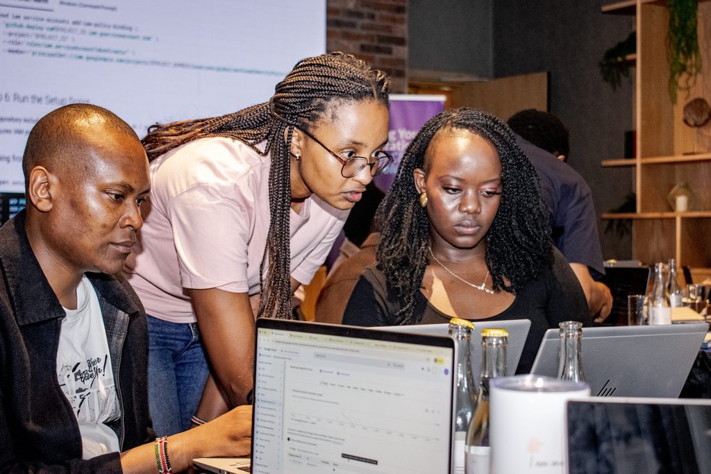 Sarah Wangari of Pawa IT’s engineering team troubleshooting a live agentic AI deployment with two attendees at Cloud Mastery 2026 in Nairobi.